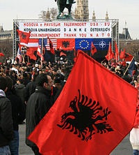 Kosovares celebrando su independencia, con la bandera de Albania flanqueada por la europea, estadounidense, OTAN y austriaca.